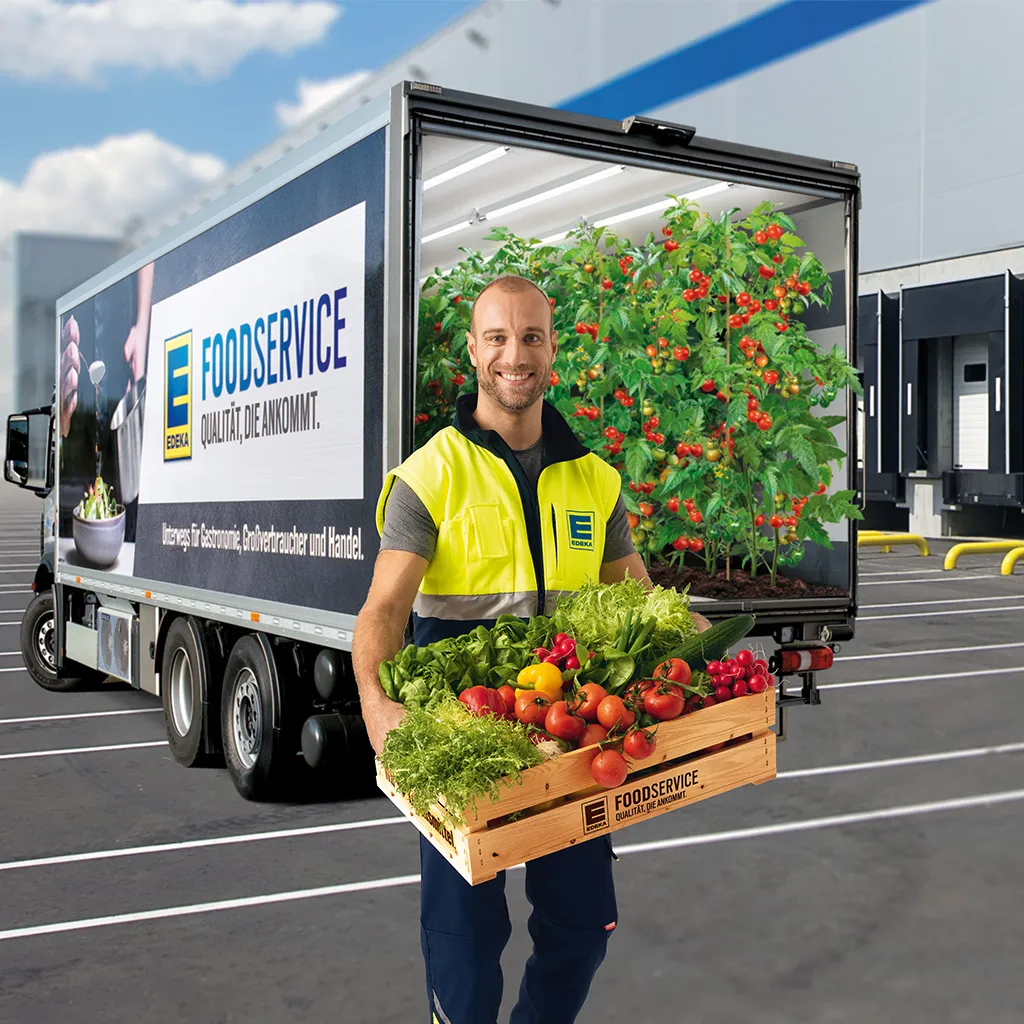 Mitarbeiter mit Gemüsekiste steht vor einem EDEKA Foodservice LKW.